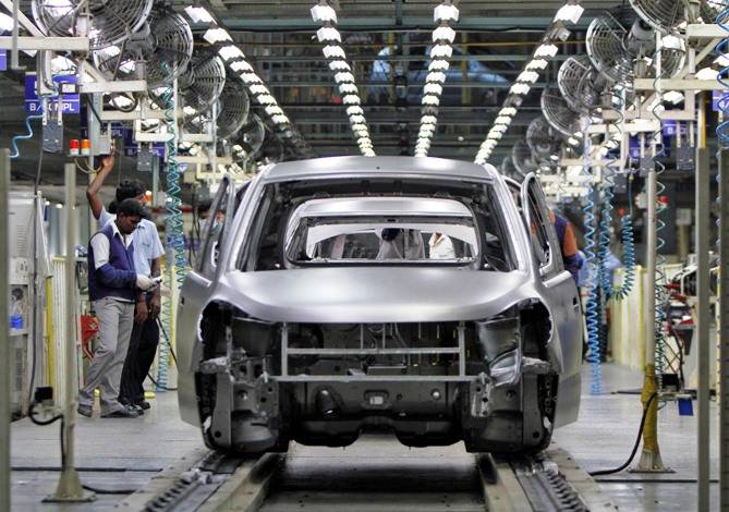 Workers stand next to the assembly line of the Hyundai Motor India Ltd plant at Kancheepuram district in Tamil Nadu.