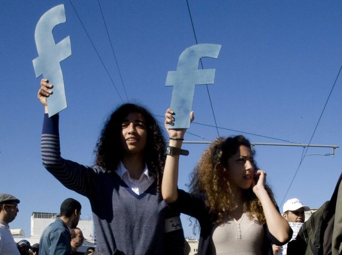 Protesters hold fs in recognition of social network site Facebook's role in the North African revolts, during a protest in Rabat.