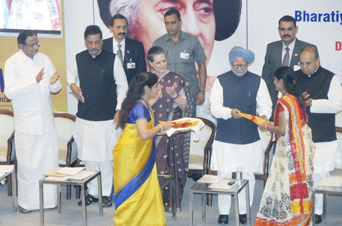 Prime Minister Manmohan Singh presents the new account kit to the first account holder, at the inauguration of the first branch of Bharatiya Mahila Bank.