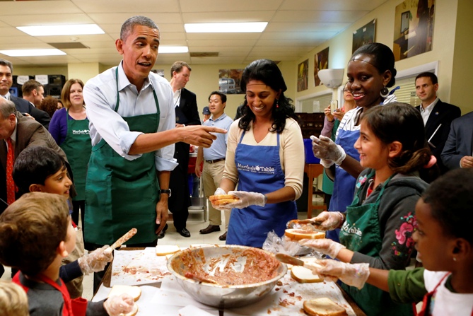 US President Barack Obama greets children and volunteers during a visit to Martha's Table, a kitchen that prepares meals for the needy.