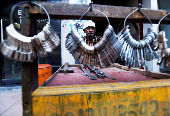 A key maker waits for customers at his stall along a road in the old quarters of Delhi.