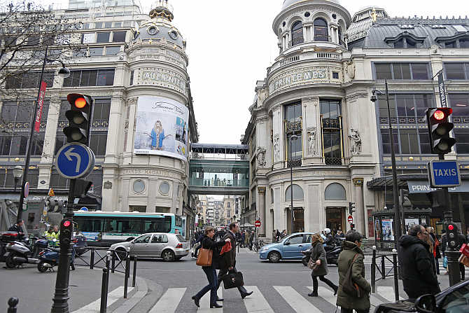 People walk past the Printemps department store in Paris, France.