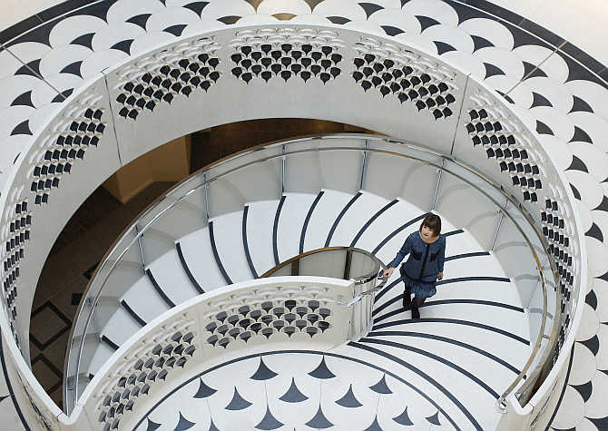 A gallery assistant poses for photographs on the spiral staircase at Tate Britain in central London, United Kingdom.