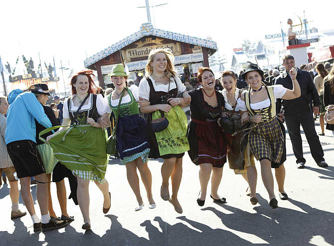 Young women pose while wearing traditional Bavarian dirndls at Munich's beer festival, Germany.