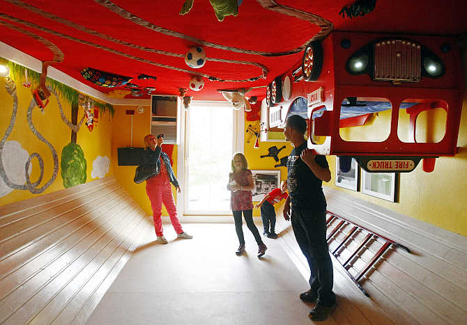 People stand inside a room of a house, which was built upside down by Polish architects Irek Glowacki and Marek Rozhanski, in the western Austrian village of Terfens.