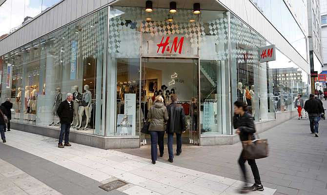 People walk past a branch store of H&M in Stockholm, Sweden.