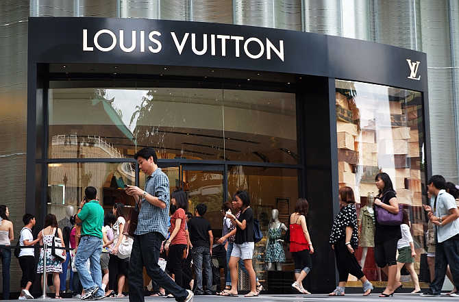 Shoppers walk past a Louis Vuitton store at the Ion Orchard shopping mall in central Singapore.