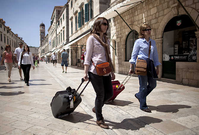 Tourists pull their luggage as they walk on Stradun street in Croatia's Unesco protected medieval town of Dubrovnik.