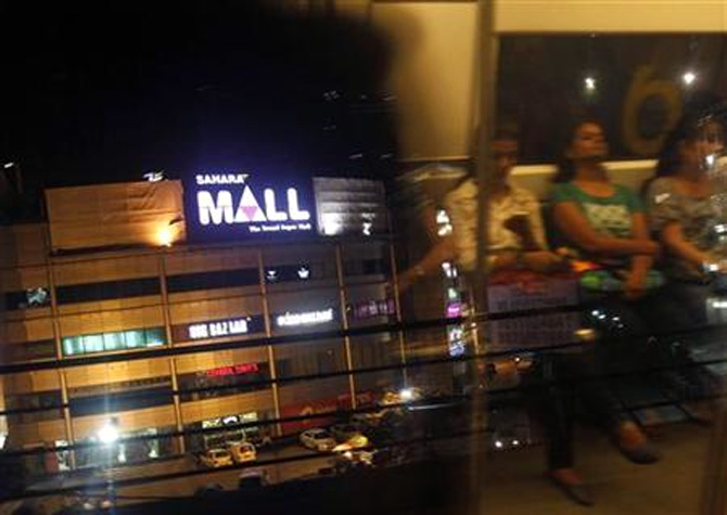 A metro train moves past Sahara Mall, a shopping centre built by Sahara group, in Gurgaon 