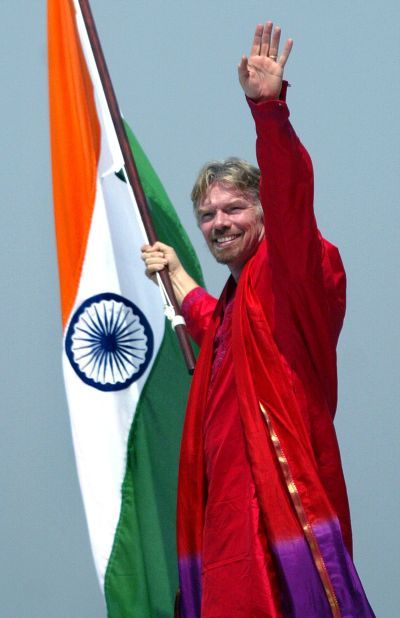 Virgin Atlantic chairman Richard Branson holds Indian national flag on the wing of a Virgin Atlantic aircraft at Bombay international airport.