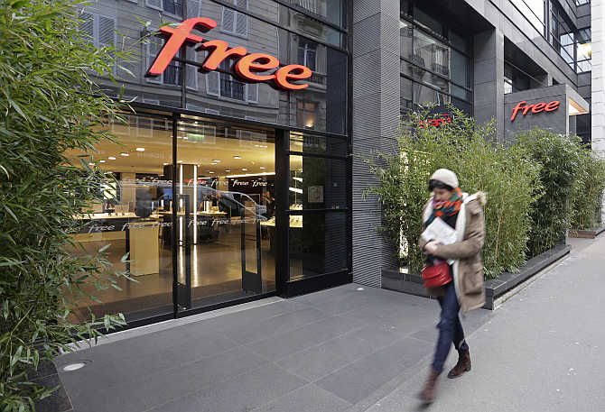 A woman walks past French Internet service provider and mobile phone operator Free's store in Paris, France.