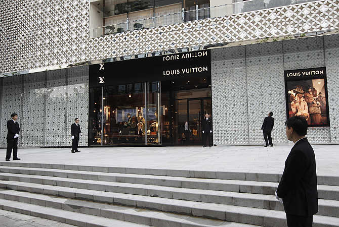 Security guards stand in front of the largest Louis Vuitton store in China, in Shanghai.
