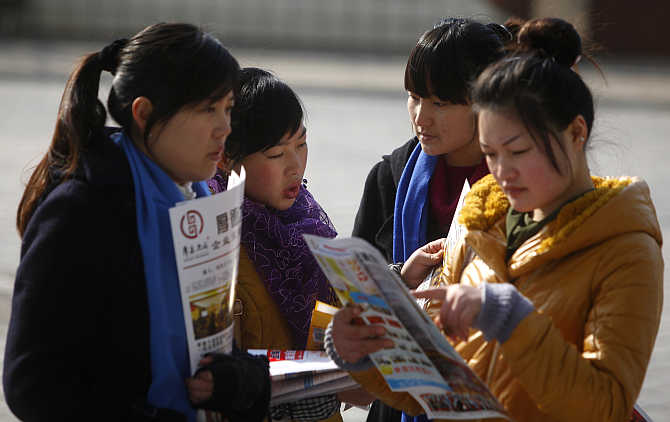 Job seekers look at employment information during a job fair in Shanghai, China.