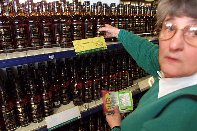 A shopper picks a bottle of whisky at the Duty Free shop at the Channel Tunnel Terminal in Coquelles, northern France.