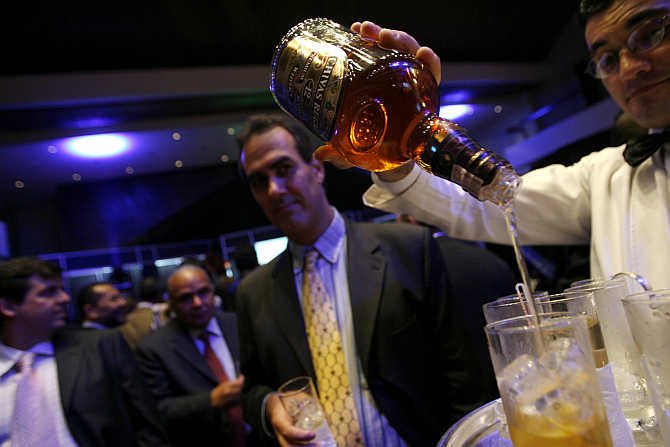 A waiter pours whisky during a Venezuelan-American Chamber of Commerce party in Caracas, Venezuela.