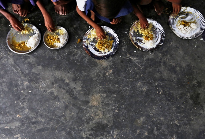 Schoolchildren eat their free mid-day meal, distributed by a government-run primary school at Brahimpur village in Chapra district of Bihar.
