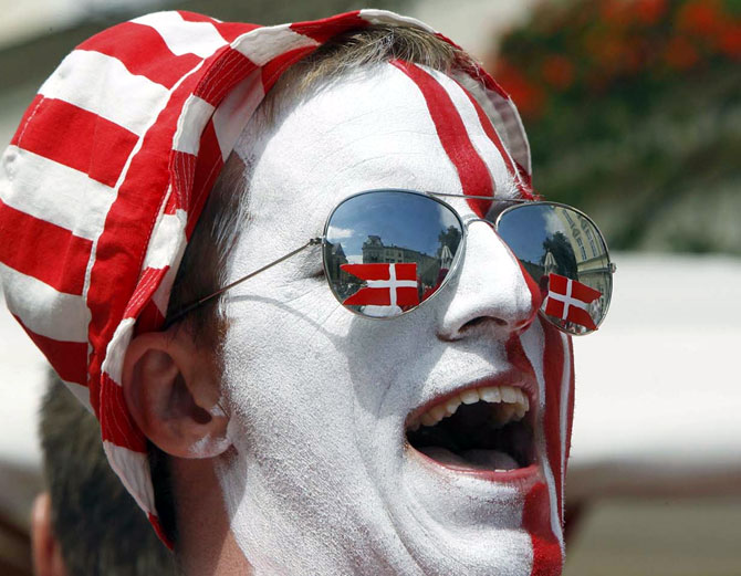 A Denmark soccer fan with his face painted in national colours.