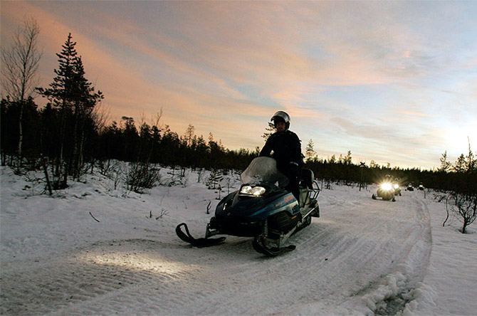  Tourists drive snowmobiles during an arctic safari at Arctic Circle near Rovaniemi, northern Finland.