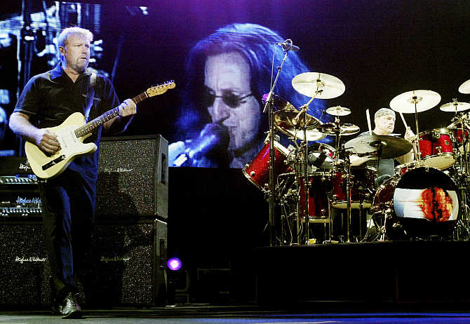Rush guitarist Alex Lifeson, left, and drummer Neil Peart, right, perform in front of a video image of singer/bassist Geddy Lee at the MGM Grand Garden Arena in Las Vegas, Nevada.