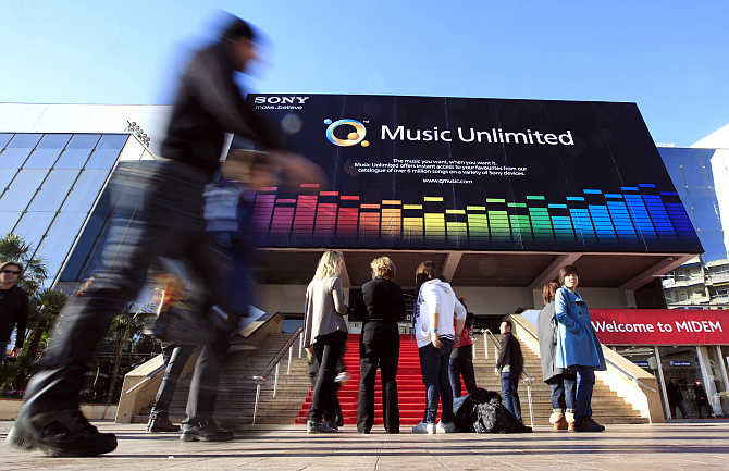 Visitors walk past the record music publishing and video music market in Cannes, France.