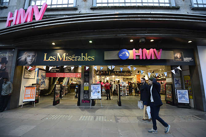 Shoppers pass an HMV shop in central London, United Kingdom.