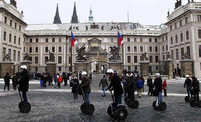 Tourists ride segways past Prague Castle, the Czech Republic.