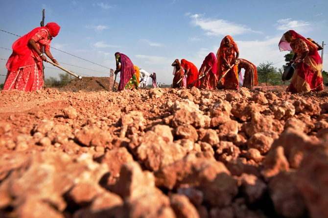 Village women labourers work at the construction site of a road at Merta district in Rajasthan.