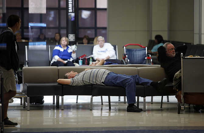 Passengers at Dallas/Fort Worth International Airport, Texas, rest before their flights.