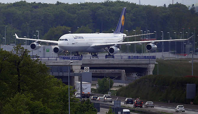 An aircraft of German air carrier Lufthansa rolls on a runway above a highway in Frankfurt, Germany.