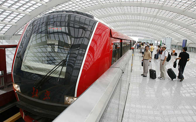 Passengers wait to board the Airport Express train at the subway station at Beijing Capital International Airport, China.