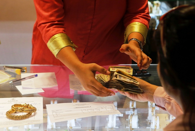 An employee receives payment from a customer inside a gold jewellery showroom in Mumbai.