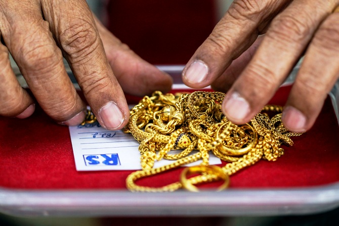 A pawn shop worker sorts through gold jewellery at Easy Money Pawn shop.