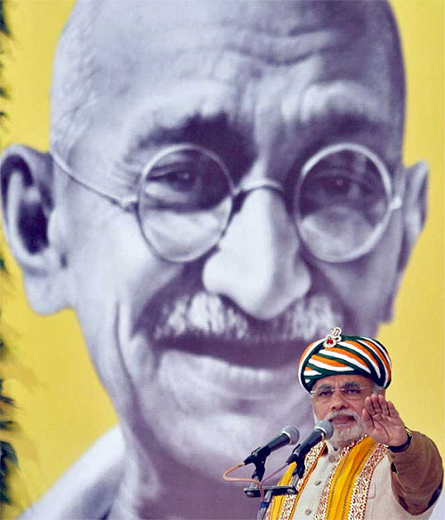 Gujarat's chief minister Narendra Modi addresses a gathering in front of a portrait of Mahatma Gandhi during his day-long fast at Godhra, Gujarat on January 20, 2012.