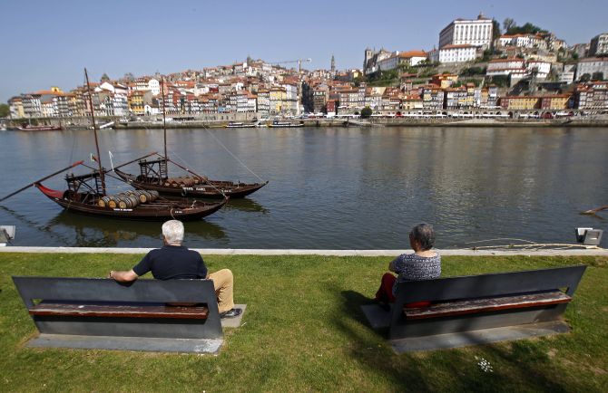 People enjoy the view along the Douro river in Porto.