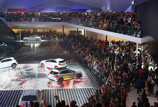 Visitors watch a car presentation at the stand of German manufacturer Mercedes Benz at the Frankfurt Motor Show, Germany.
