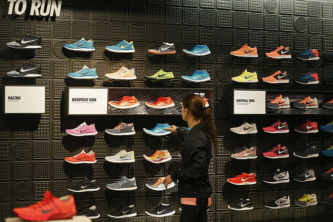 A woman picks up a shoe in the Nike store in Santa Monica, California.