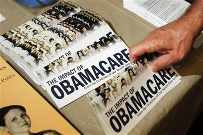 A Tea Party member reaches for a pamphlet titled ''The Impact of Obamacare'' in Littleton, New Hampshire.
