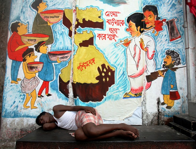 This file photograph shows a man sleeping in front of graffiti in Kolkata on April 30, 2009.