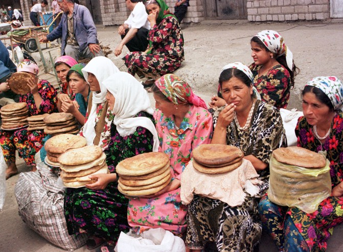 Tajik women sell bread in a street market.