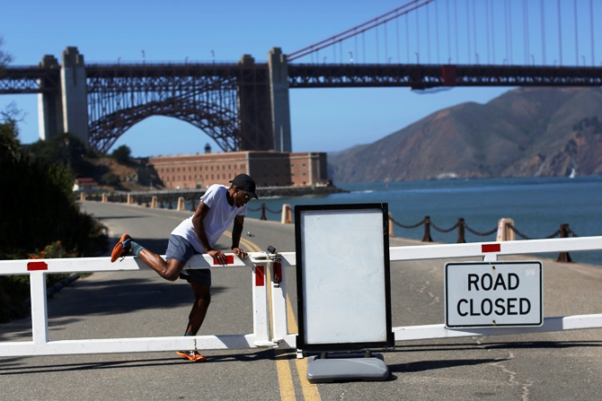 A runner climbs over a road gate leading to Fort Point National Historic Site, which has been closed due to the federal government shutdown, in San Francisco, California.