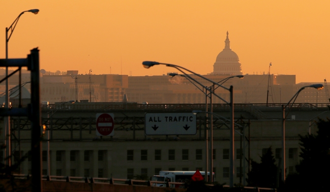 The dome of the US Capitol rises over the Pentagon and other federal buildings in Washington during sunrise. 