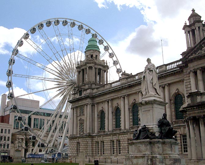 A statue of Britain's Queen Victoria at Belfast's City Hall stands close to a new 60-metre high Ferris wheel attraction, in Belfast, Northern Ireland.