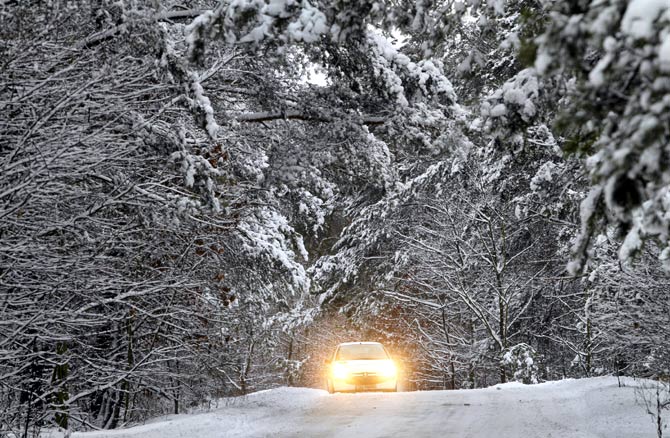 A car is seen on a road after heavy snowfall in Torun, northern Poland.