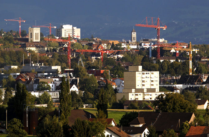 Apartment buildings and construction cranes are pictured in Affoltern, outside Zurich.