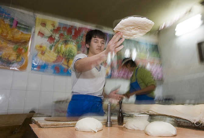 Men bake traditional bread at a private bakery in Tashkent, Uzbekistan.
