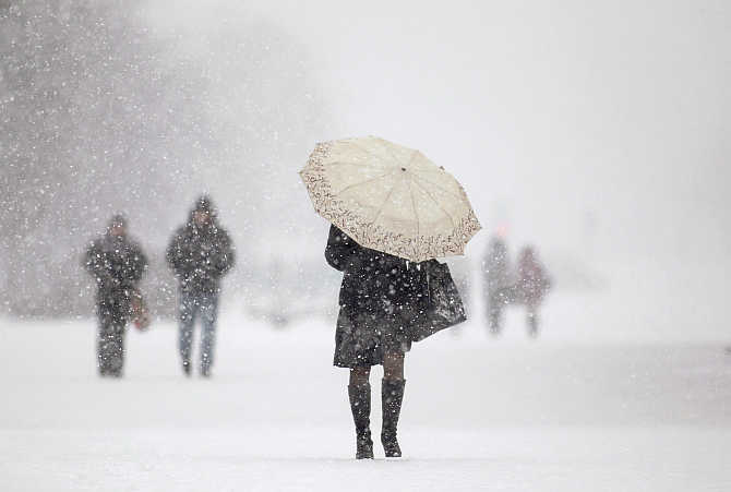 People walk during heavy snowfall in central Minsk, Belarus.