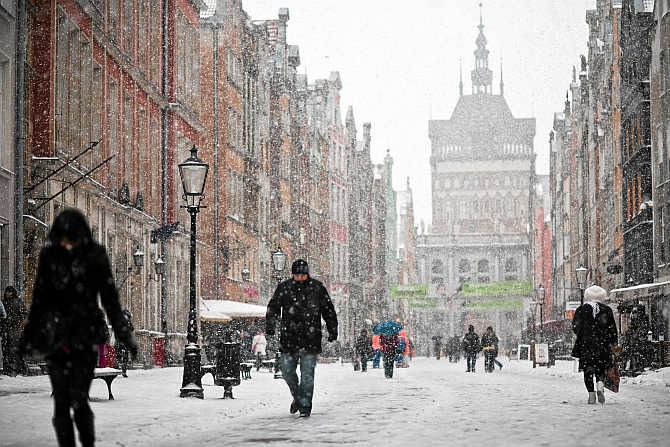 People walk on the main street in the Old Town during heavy snowfall in Gdansk, northern Poland.