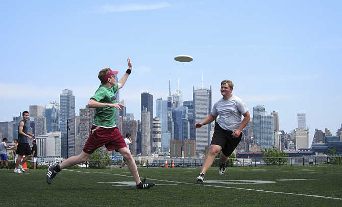 With the skyline of New York behind them, people play a game of ultimate frisbee in a park in Weehawken, New Jersey, United States.