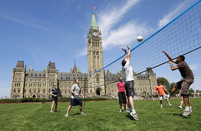 People play volleyball on the front lawn of Parliament Hill in Ottawa, Canada.