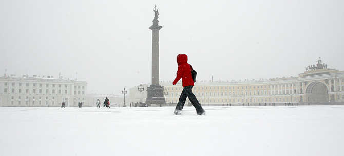 A woman crosses Dvortshovaya Square (Palace Square) in central StPetersburg during a snowstorm, Russia.